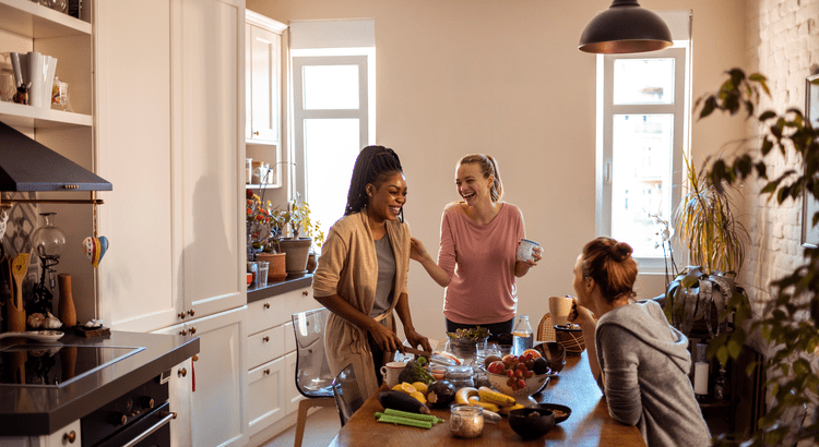 Group of ladies enjoying food and laughter around the kitchen table